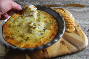 creamy dill pickle dip being served on crackers