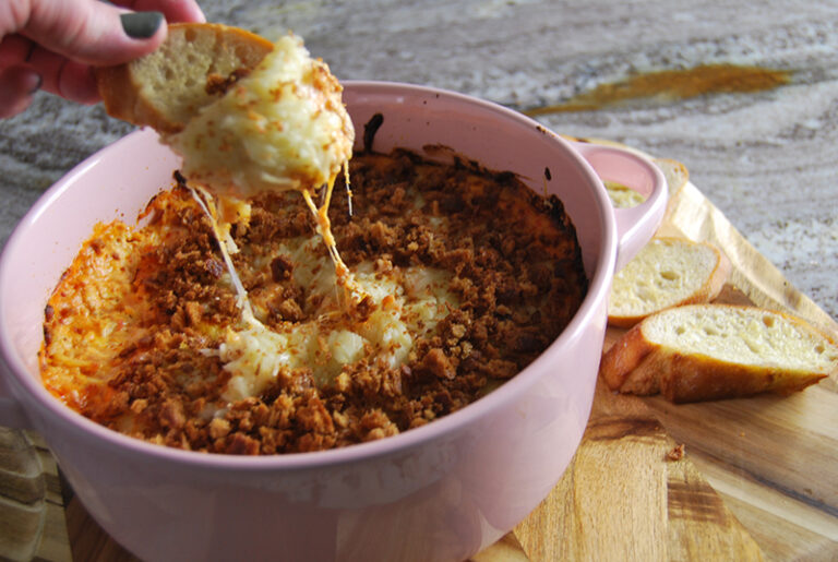 Creamy and delicious chicken marinara dip being served with a garlic toast