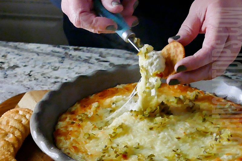 creamy dill pickle dip being served on crackers