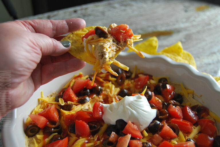 easy layered taco dip served on a tortilla chip