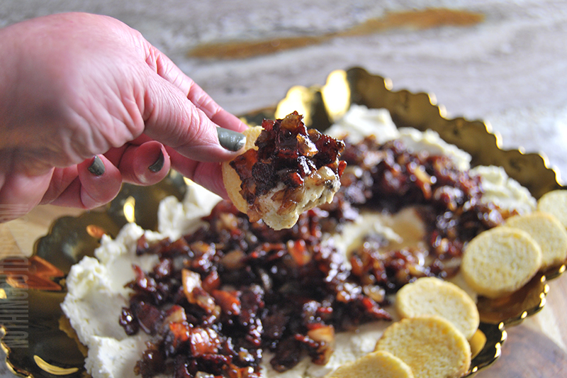 Boursin with bacon onion jam dip being served on a crostini