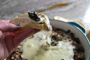Stuffed mushroom dip with melty mozzarella cheese served on toasty bread
