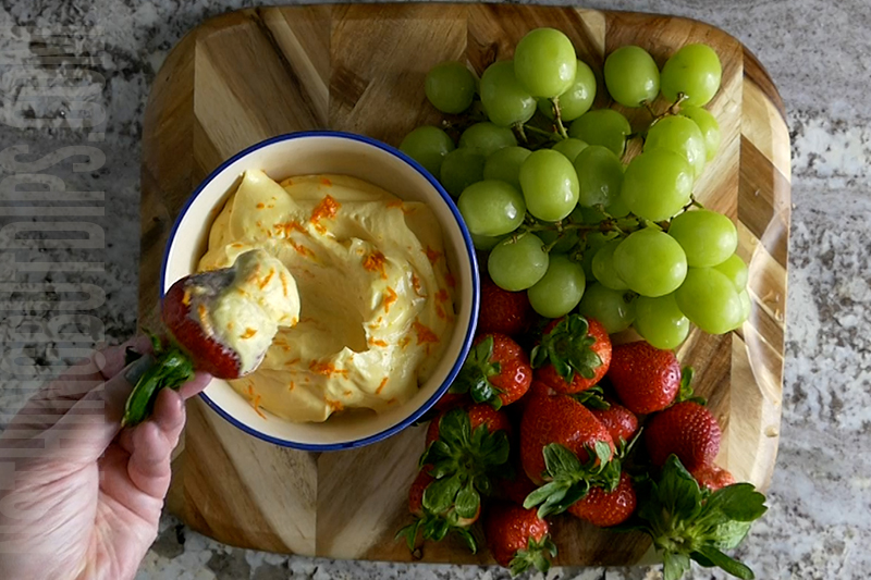 With a hand blender, mix together cream cheese, orange juice concentrate and vanilla. Then slowly mix in the powdered sugar until smooth. Transfer the mixture into a serving dish. Garnish with orange zest.