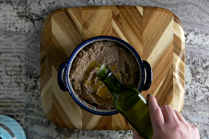 adding olive oil to the olive puree as a garnish