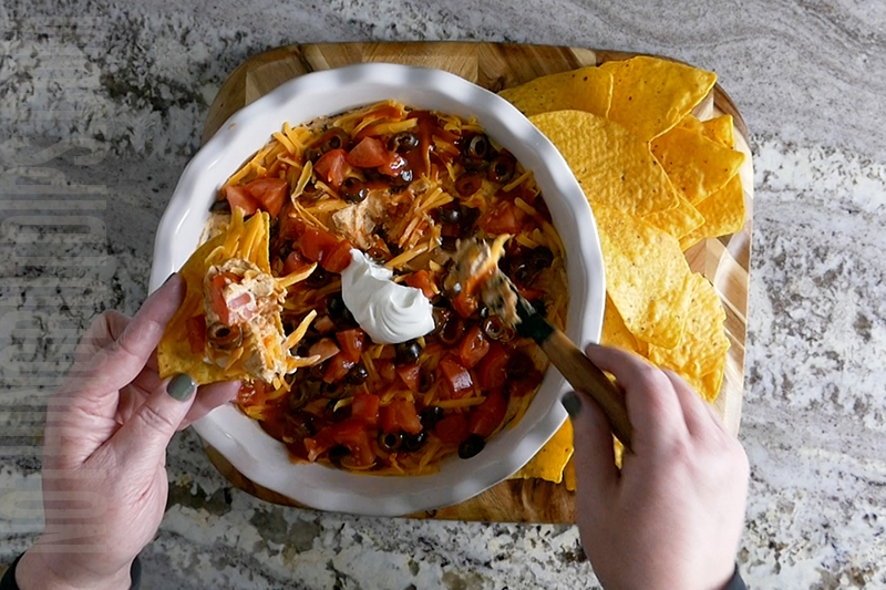 easy layered taco dip served on a tortilla chip 