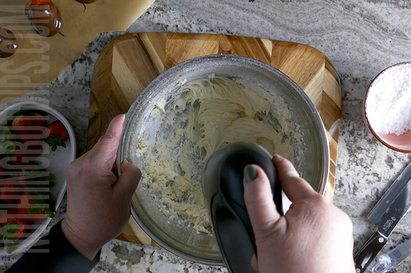 Use hand mixer to blend the ingredients for the creamy base of the chocolate covered strawberries dip