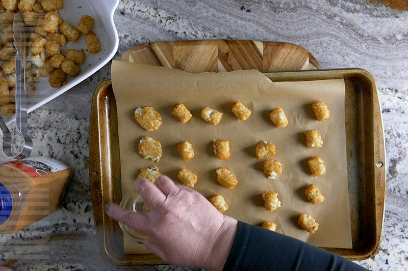 using a small glass to smash the tater tot chips