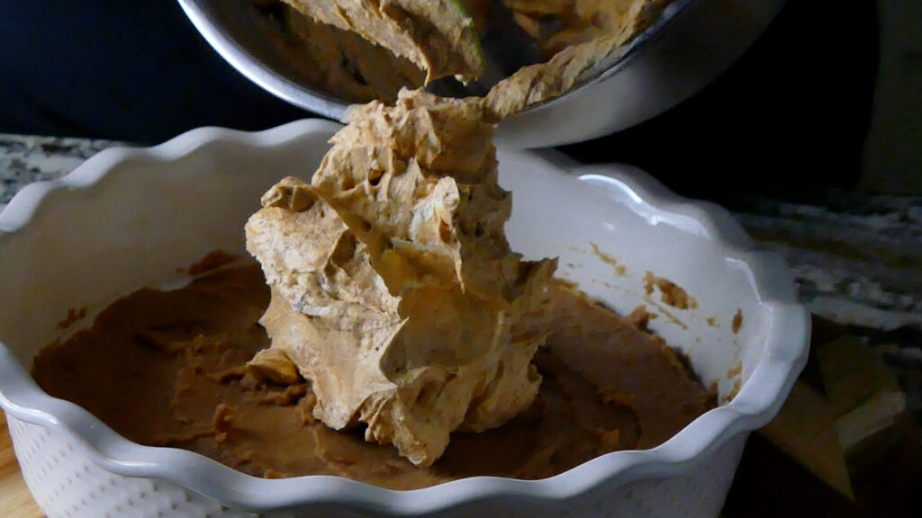 Transferring the creamy mixture and second layer of the layered taco dip to the serving container