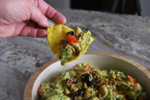 Homemade Guacamole served on a tortilla chip