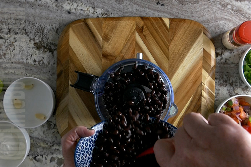 adding black beans to a mini food processor