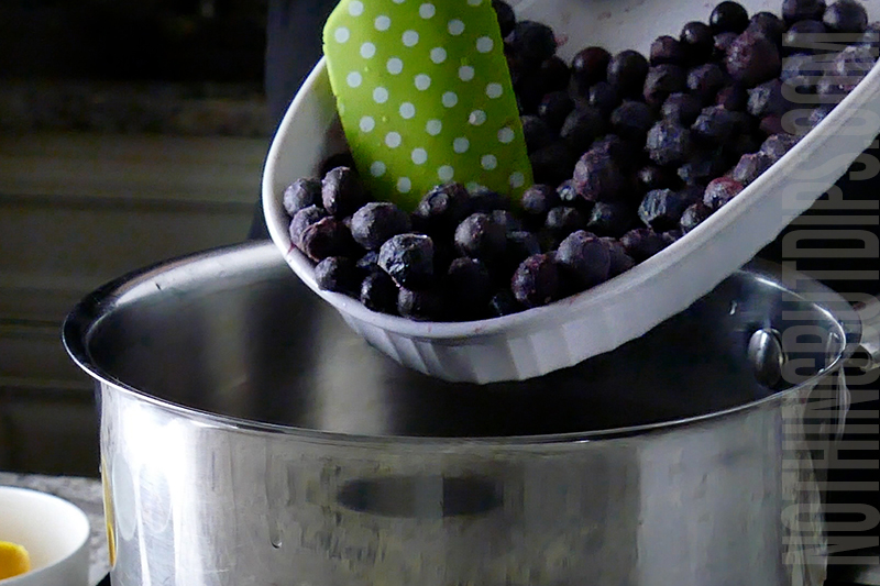 adding frozen blueberries to the sauce pan