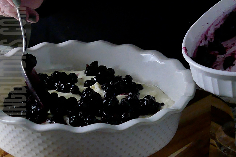 adding the blueberry compote to the top of the blueberry and lemon dip