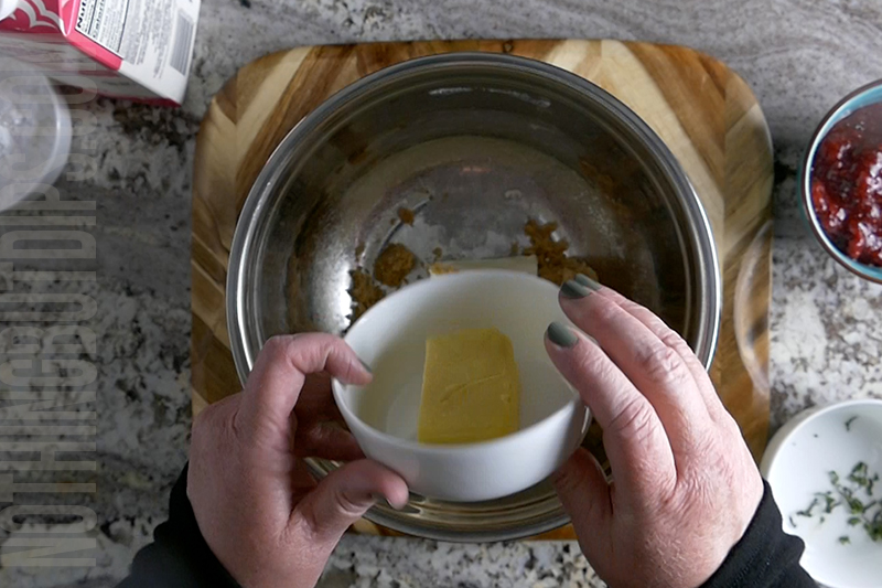 adding butter to a mixing bowl to make the creamy base for strawberry basil cheesecake dip