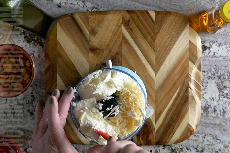 adding parmesan cheese to the mini food processor to create feta whip