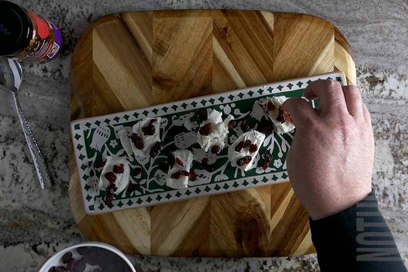 adding sweetened dried cranberries to the goat cheese medallions