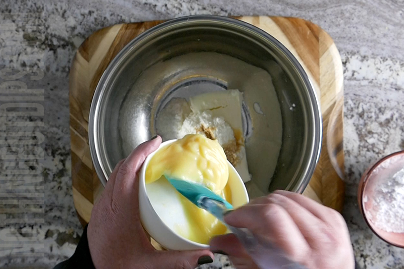 adding the lime curd to the bowl for key lime pie dip 