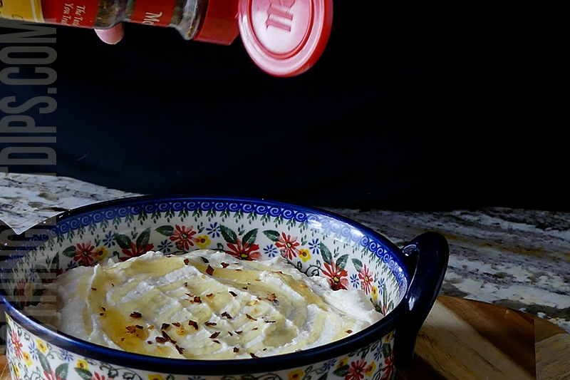 sprinkling red chili flakes onto the feta whip