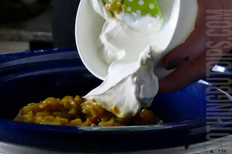 add the sour cream to the crockpot for the Mexican corn crockpot dip