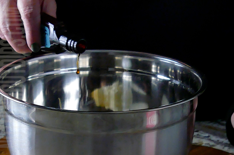 pouring in some vanilla to the blueberry and lemon dip mixture
