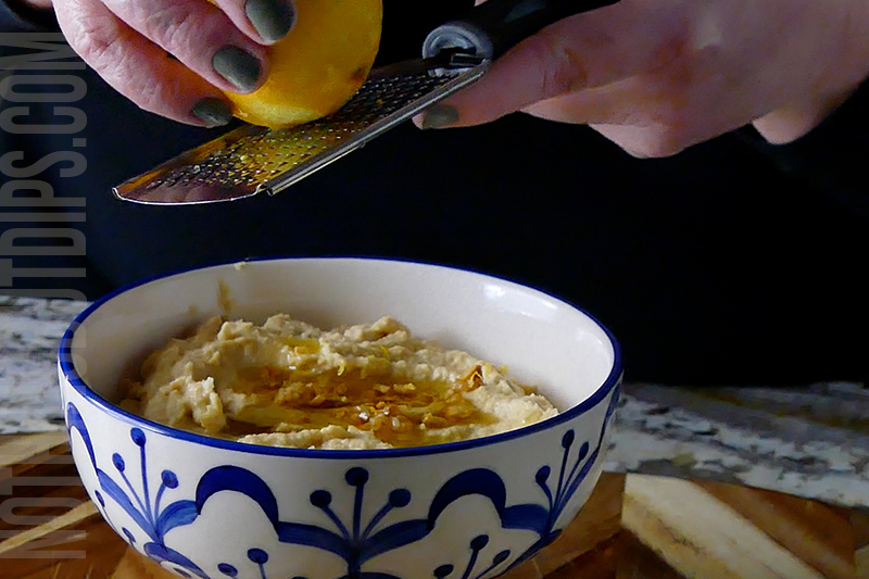 adding lemon zest to the top of the lemon garlic hummus