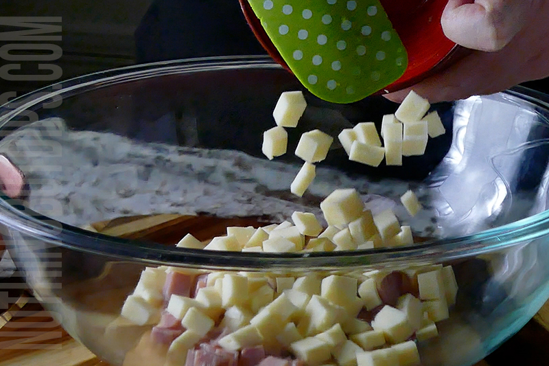 adding the diced cheese to the bowl for making Italian sub dip