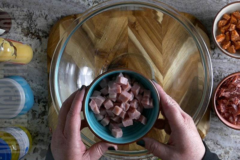 adding the diced ham to the bowl for making Italian sub dip