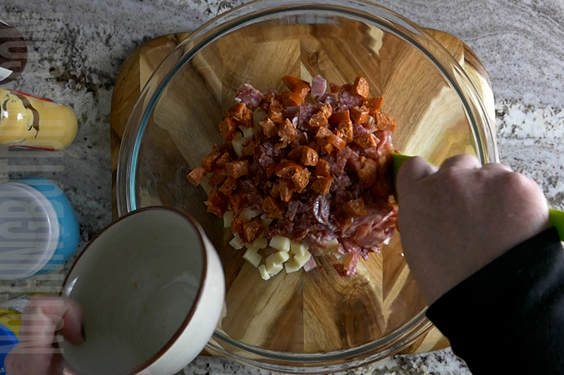 adding the diced pepperoni to the bowl for making Italian sub dip