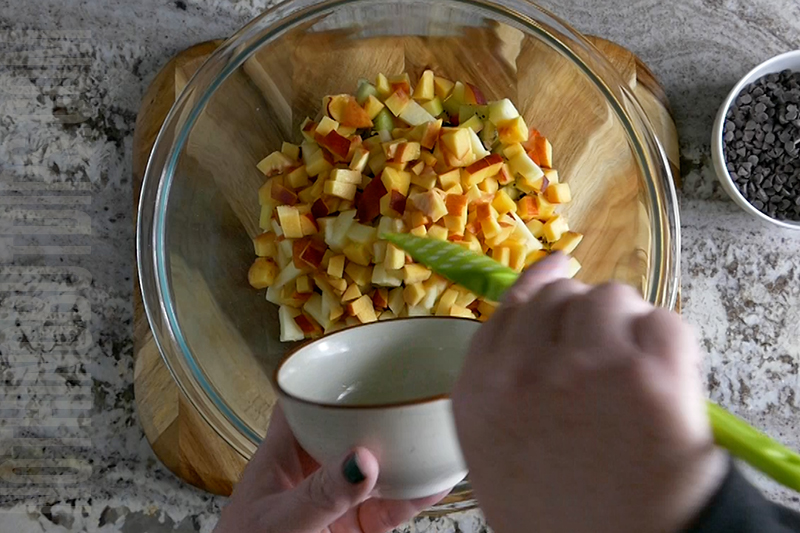 adding nectarines to a bowl to make fruit salsa
