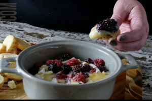 Brie with Berries and herbs being served on crusty bread