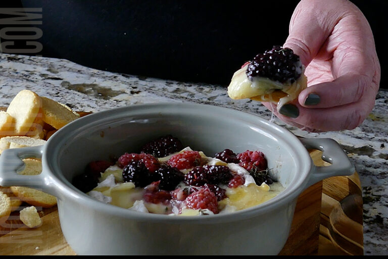 Brie with Berries and herbs being served on crusty bread