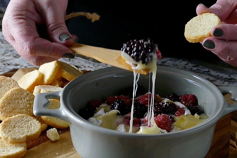 serving the melted brie with berries and herbs