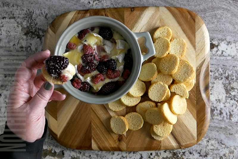 serving the melted brie with berries and herbs