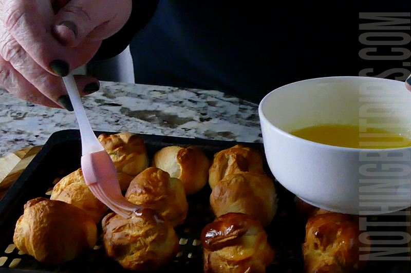 brushing each of the baked dough balls with melted butter