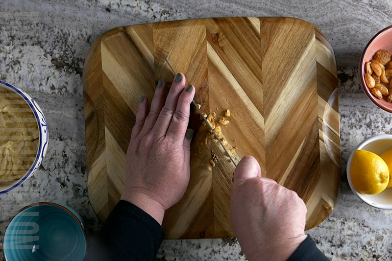 mincing roasted garlic for lemon garlic hummus garnish