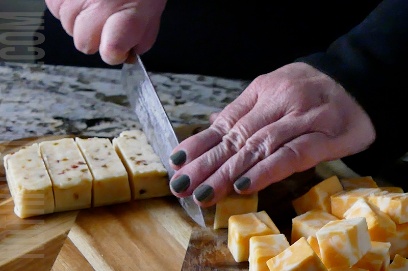 chopping the cheeses for the Mexican corn dip