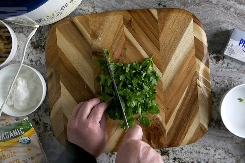 chopping the cilantro for the Mexican corn dip
