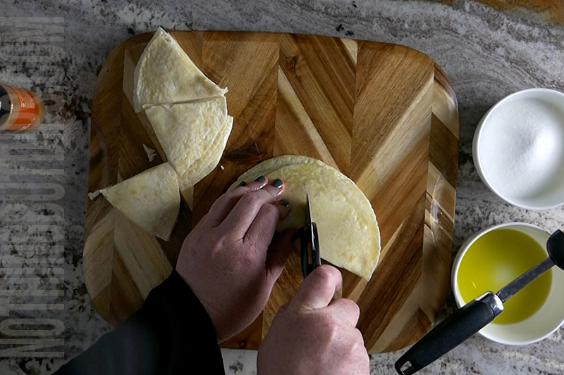 use a pizza cutter to cut the tortillas into triangle chips