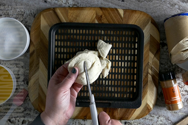 cutting the biscuit dough to make donuts