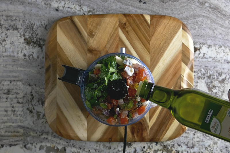 adding olive oil to the mini food processor when making black bean dip puree
