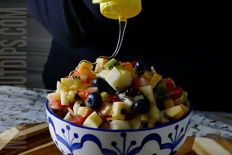 drizzling the fruit salsa with honey
