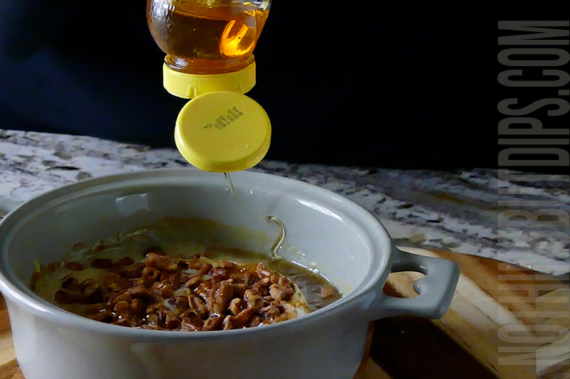 drizzling honey onto the top of the melted brie with fig jam and honey roasted pecans