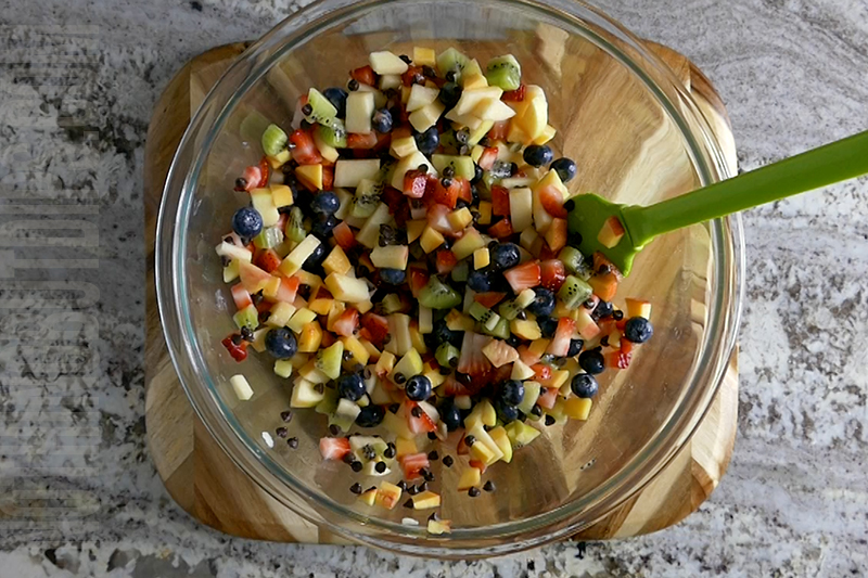 mixing ingredients together to make fruit salsa