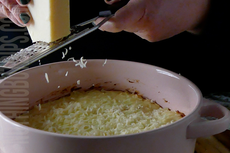 adding grated fresh parmesan cheese to the top of the chicken mixture to the top of the baked parmesan garlic wing dip