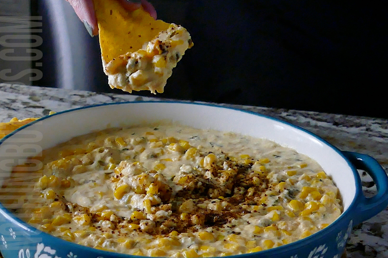 easy Mexican corn crockpot dip being served on a tortilla chip
