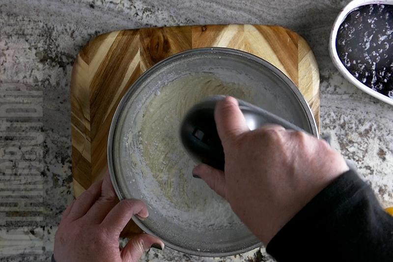 mixing the creamy lemon base for the blueberry and lemon dip with a hand mixer