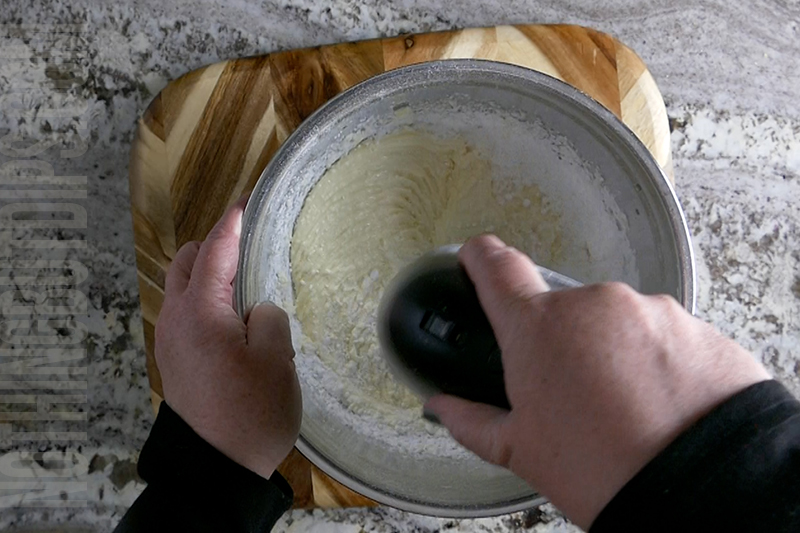 mixing the ingredients with a hand mixer to make the base for the key lime pie dip