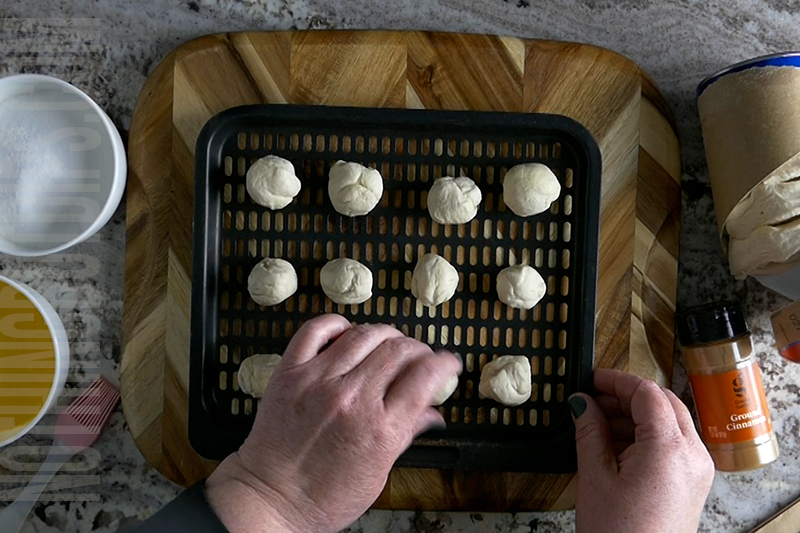 placing the balls of biscuit dough onto a tray to place in the air fryer