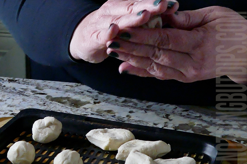 rolling the biscuit dough pieces into balls for donuts