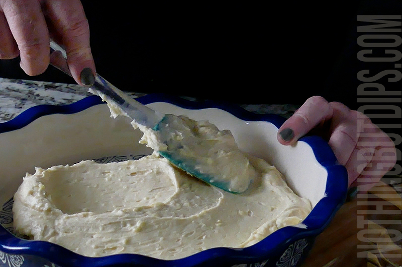 spreading the creamy base for strawberry basil cheesecake dip in the serving dish