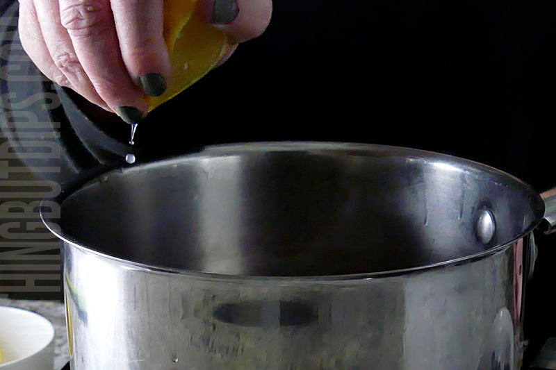 squeezing lemon into the saucepan for the blueberry compote